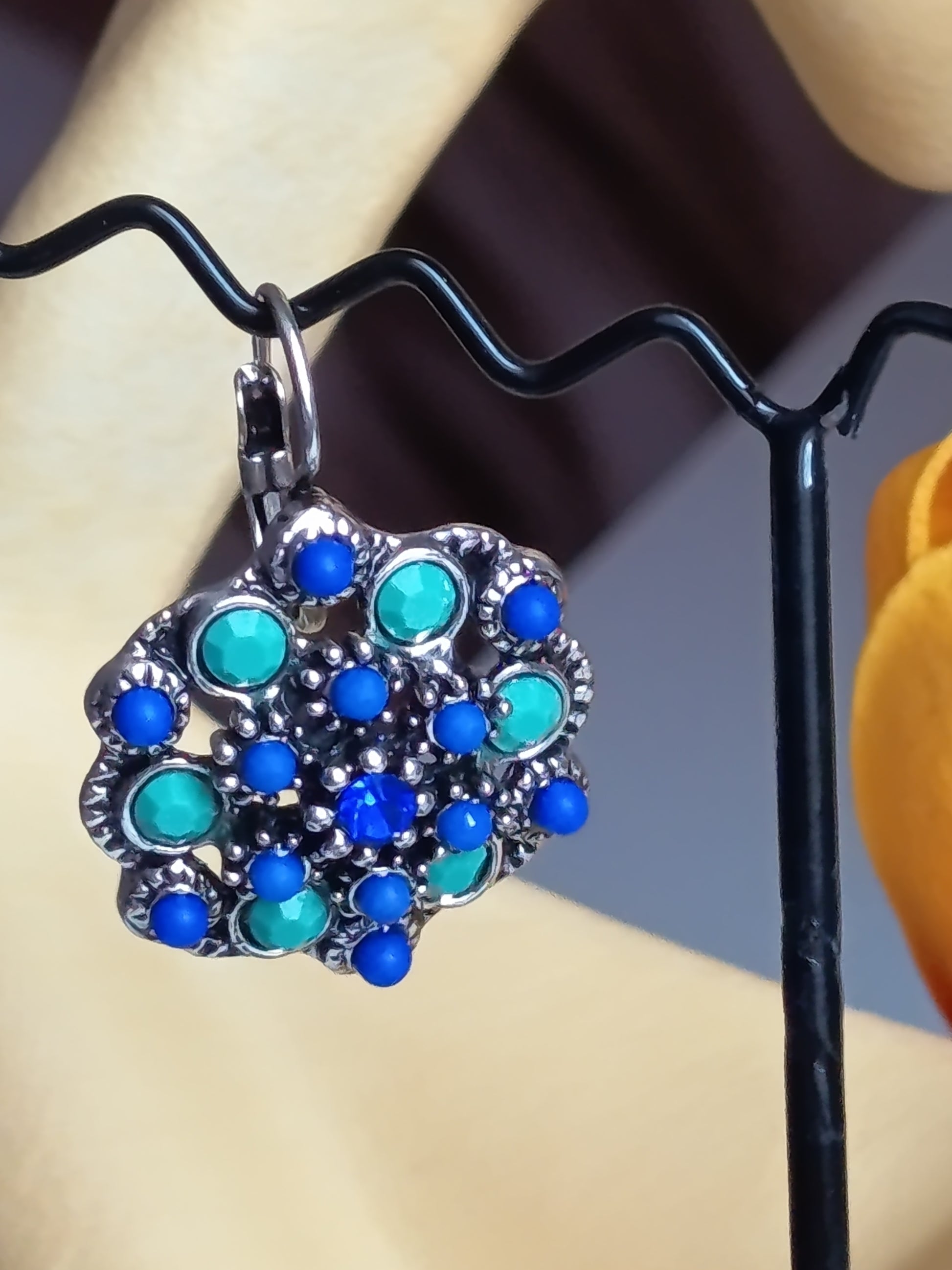 Gros plan sur le travail du métal argenté et le sertissage des pierres bleues et turquoise." 🔍💎