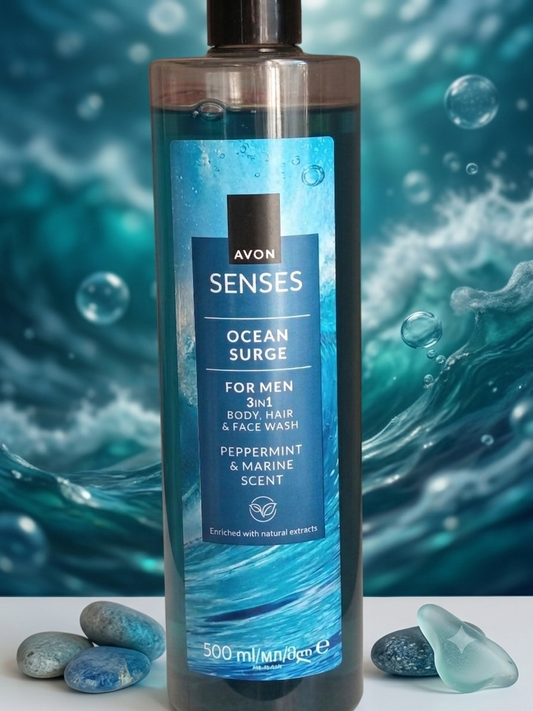 Flacon de gel douche 3-en-1 pour homme Avon Senses Ocean Surge de 500 ml, senteur menthe poivrée et marine, posé devant un fond aquatique avec des galets.