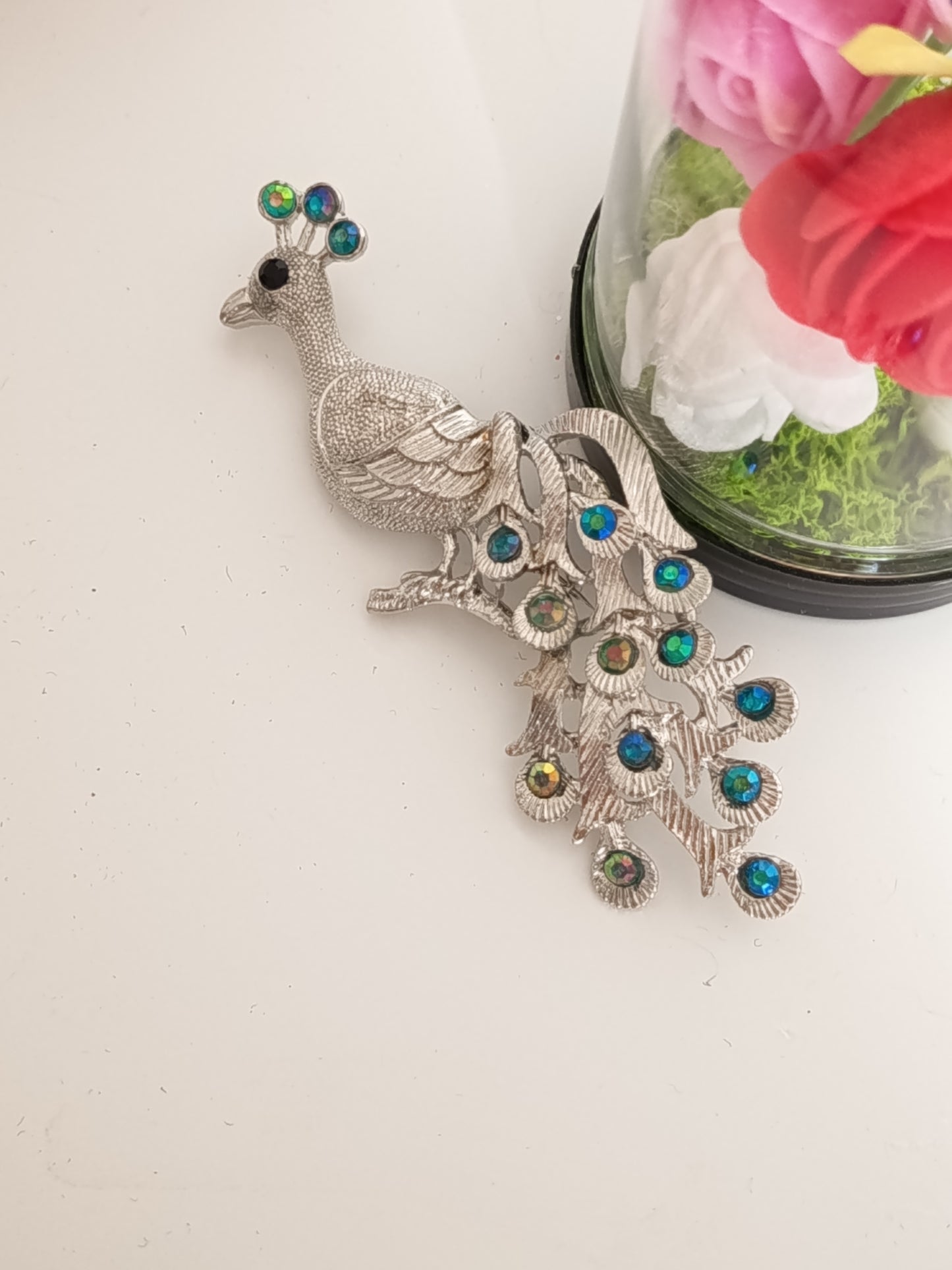 Broche paon vinage en métal argenté et cristaux bleus et verts - Vue principal.
