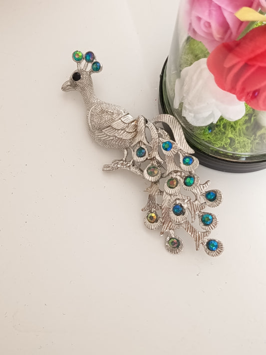 Broche paon vinage en métal argenté et cristaux bleus et verts - Vue principal.
