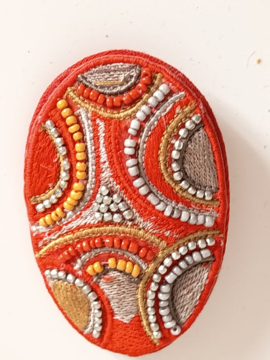 Broche ovale brodée main rouge et argent avec perles de rocailles jaunes et orange